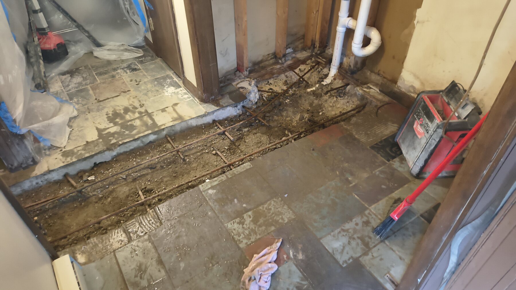 Plumbing-access floor restoration: Before — floor opened for access